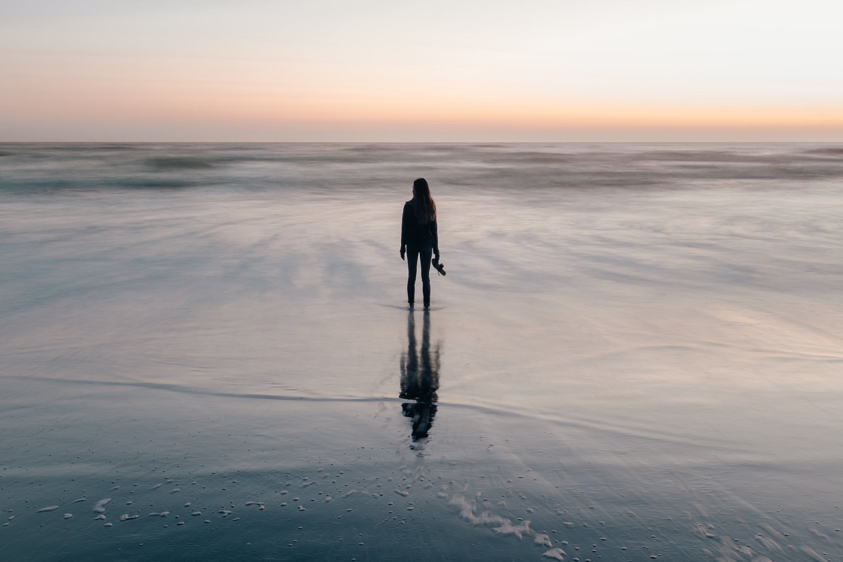 girl standing in ankle high water on beach