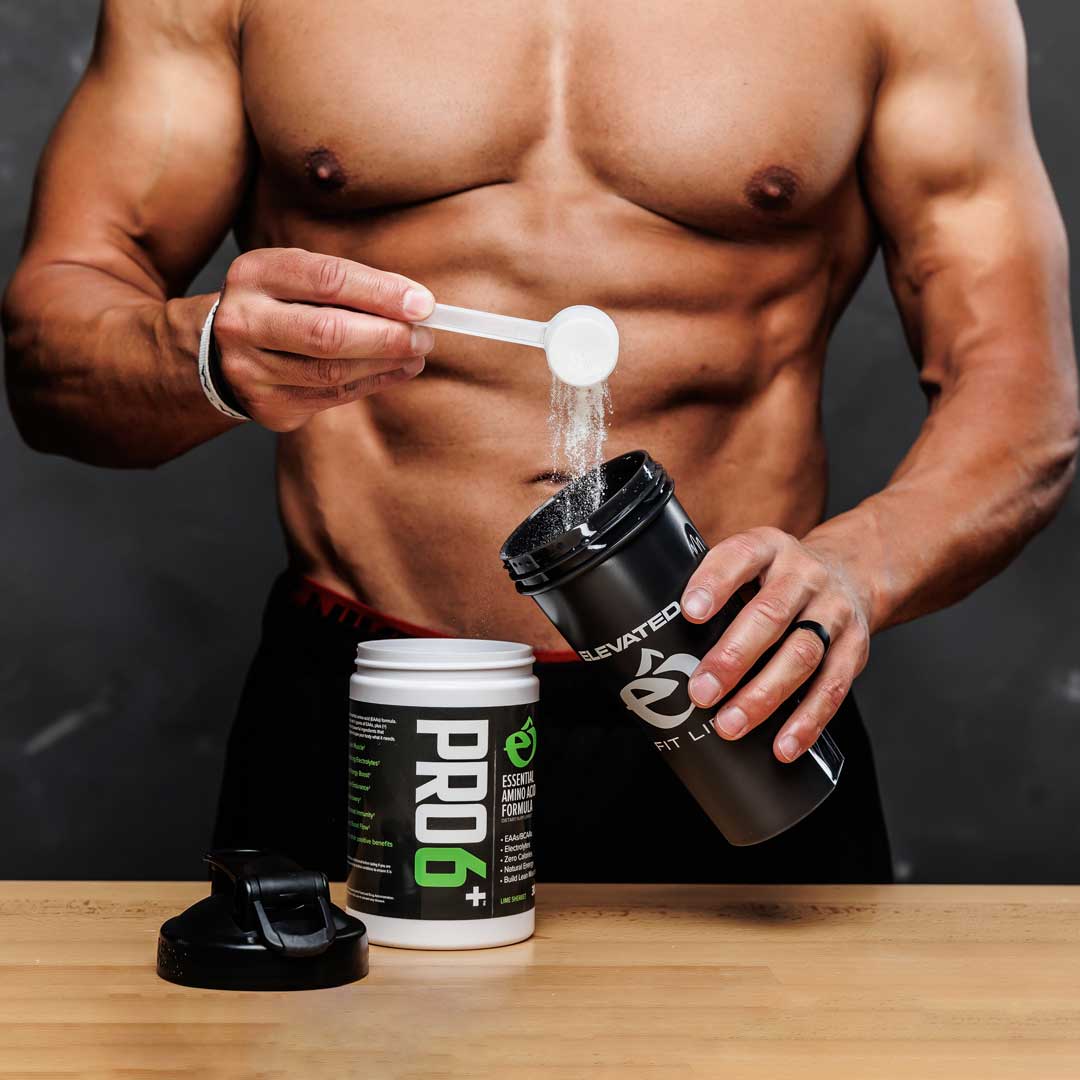 Muscular person preparing a supplement shake withLEVATED and PRO6+ products on a wooden surface.