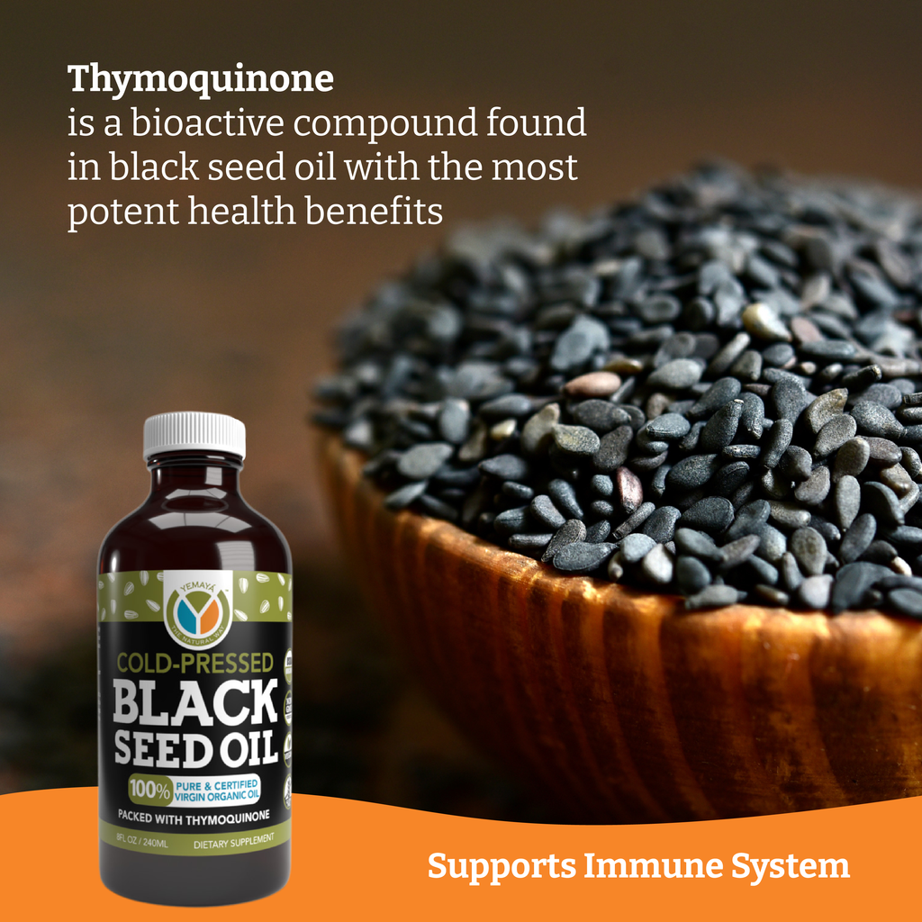 Black seed oil bottle with text about thymoquinone and health benefits on a wooden bowl of black seeds.