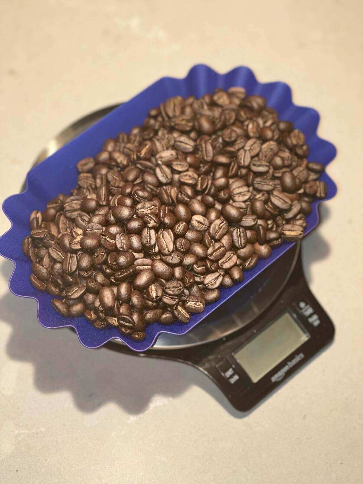 Coffee beans on a digital kitchen scale with a blue rim