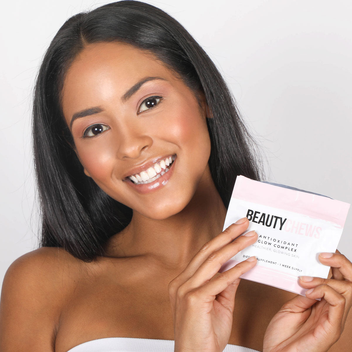 Woman holding a skincare product with a white background