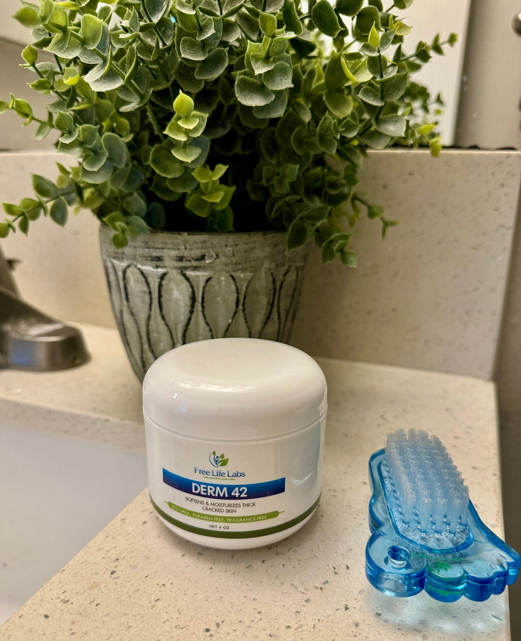 Jar labeled 'Derm 42' on a bathroom counter with a plant and brush in the background