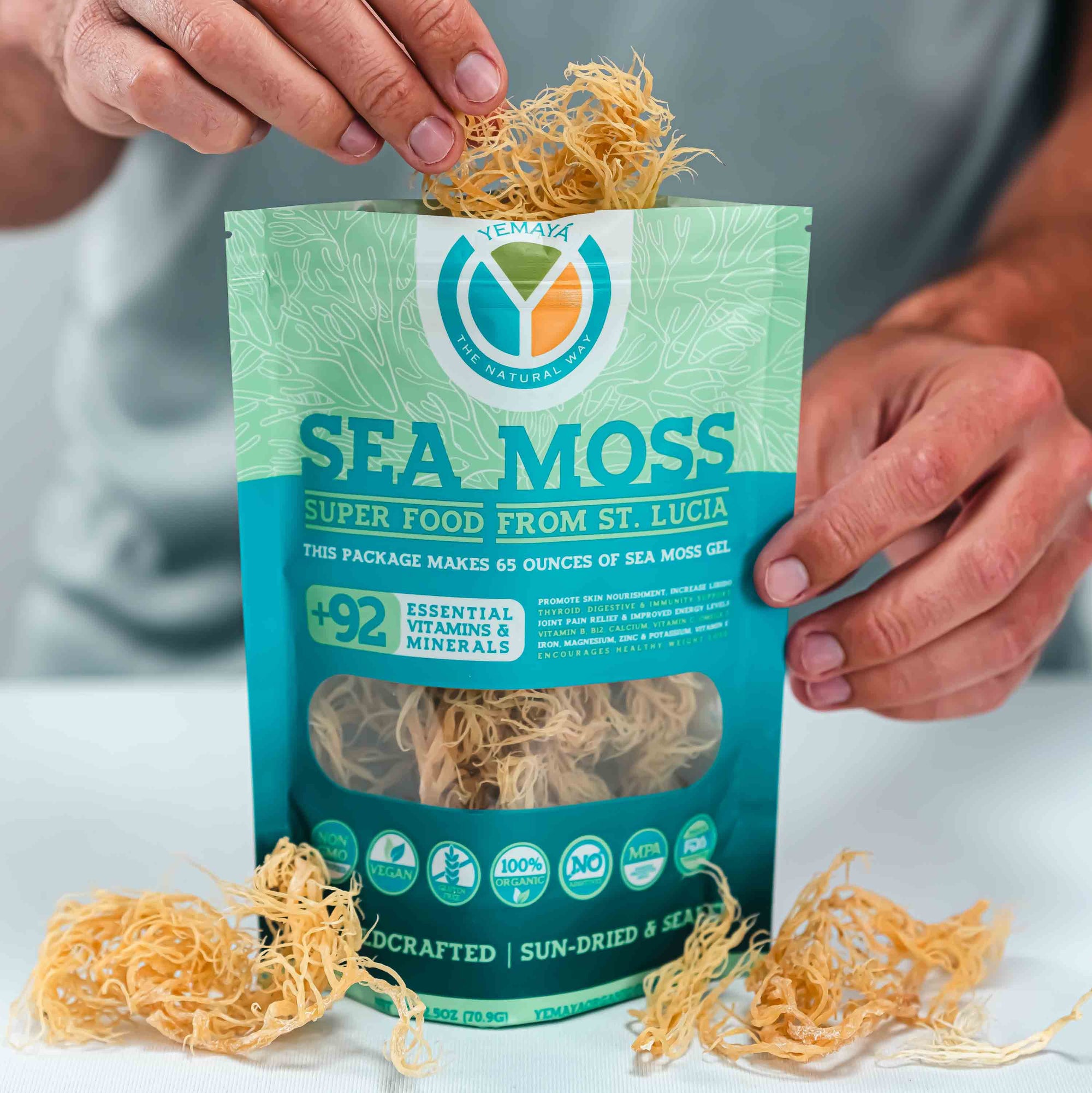 Person holding a package of sea moss with visible brand logo on a neutral background