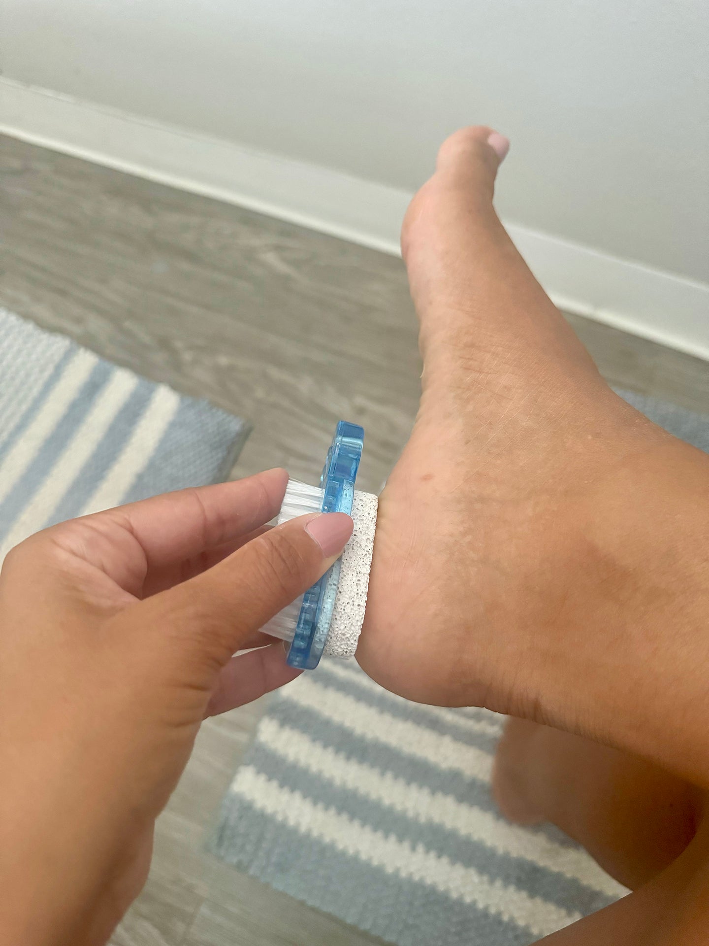 Hand holding a blue bandage over a wound on a white surface.