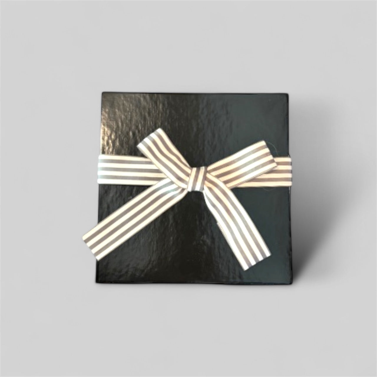 Black gift box with a white ribbon on a gray background
