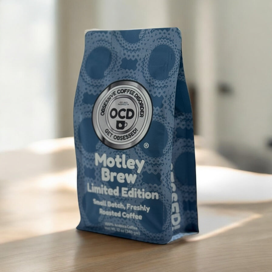 Blue coffee bag labeled 'Motley Brew Limited Edition' by OCD Coffee on a wooden surface.
