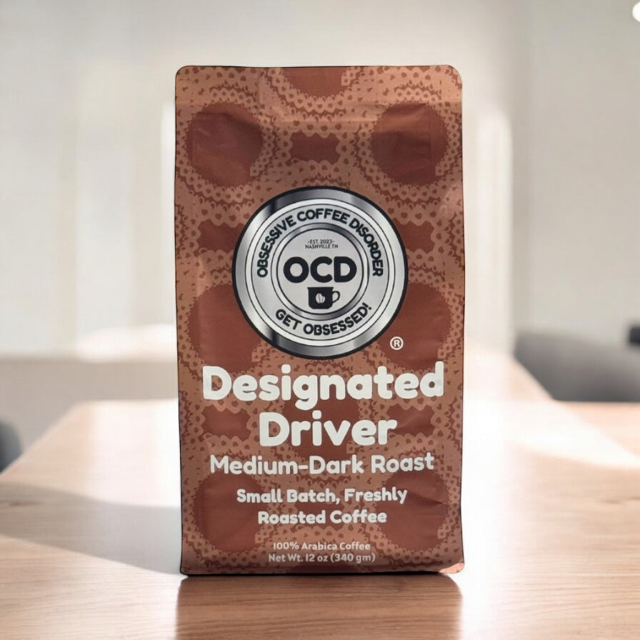 Coffee bag labeled 'Designated Driver' by OCD Coffee on a wooden surface.