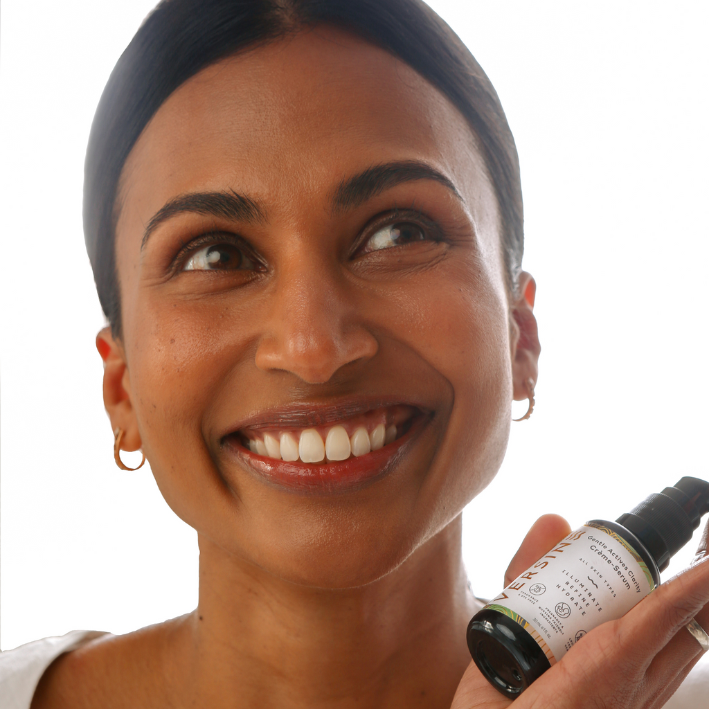 Woman holding a bottle of Sk inventives skincare product against a white background