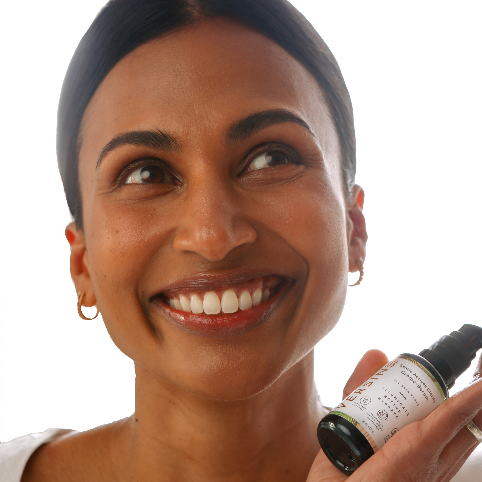 Woman holding a bottle of Sk inventives skincare product against a white background
