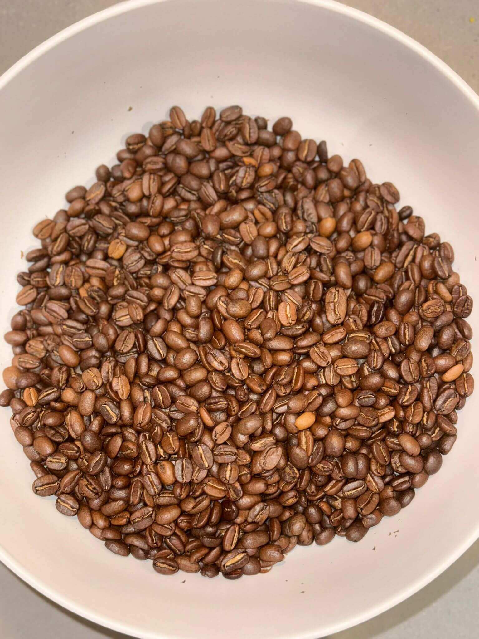Roasted coffee beans in a white bowl