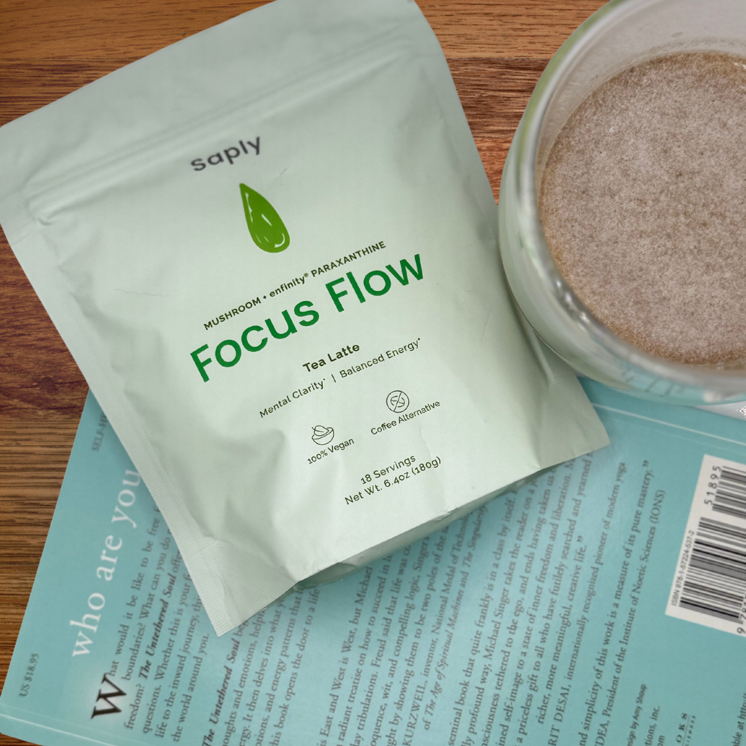 Saply Focus Flow tea package on a wooden surface with a jar of brown powder.